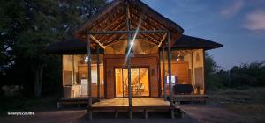 ein kleines Haus mit einem Dach auf einer Holzterrasse in der Unterkunft Hippo Lagoon Cabin in Ntabis