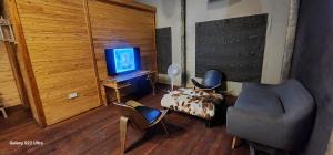 ein Wohnzimmer mit einem Stuhl und einem TV in der Unterkunft Hippo Lagoon Cabin in Ntabis