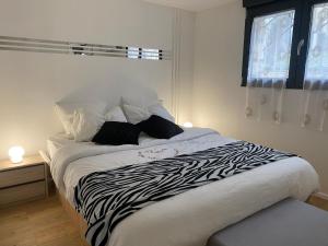 een bed met zebraprint in een slaapkamer met een raam bij ÉDEN in Vitry logement entier in Vitry-sur-Seine