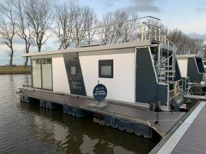 a house boat parked on a dock on the water at EVASION in Nieuwpoort