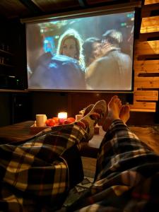 a person laying on the floor watching a movie on a tv at Kazbegi Story in Stepantsminda