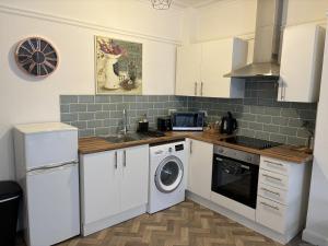 a kitchen with a washing machine and a sink at Urban Heights, Central BH1 in Bournemouth