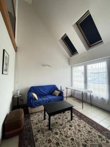 een woonkamer met een blauwe bank en een tafel bij Résidence Dahouet - 2 Pièces pour 4 Personnes 804 in Pléneuf-Val-André