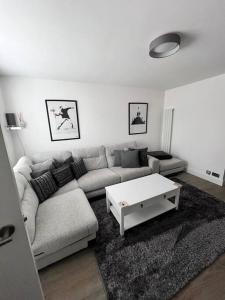 a living room with a couch and a coffee table at Luxury Ground Floor Maisonette in Hounslow