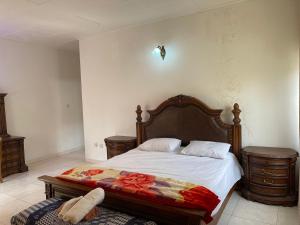 1 dormitorio con 1 cama y 2 mesitas de noche en AGASTEV Guesthouse GH, en Accra