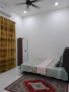 um quarto com uma cama e uma ventoinha de tecto em Homestay Legasi Haji Ali em Kuala Terengganu