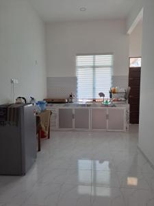 uma cozinha com um lavatório e um frigorífico em Homestay Legasi Haji Ali em Kuala Terengganu
