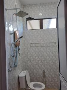 uma casa de banho com um WC e um chuveiro com uma janela em Homestay Legasi Haji Ali em Kuala Terengganu