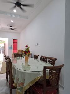 uma mesa de jantar com cadeiras e uma ventoinha de tecto em Homestay Legasi Haji Ali em Kuala Terengganu
