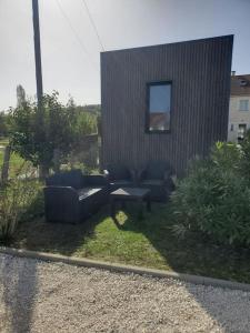 einen Hof mit Sofas, einem Tisch und einem Gebäude in der Unterkunft MarcouBox in Marcoussis