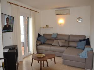 ein Wohnzimmer mit Sofa und Tisch in der Unterkunft Casa bien cuidada con piscina comunitaria, terrazas y cerca de la playa en L'Estartit - ES-323-42 in L'Estartit