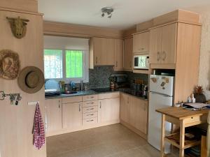 eine Küche mit weißen Schränken und einem Holztisch in der Unterkunft Casa bien cuidada con piscina comunitaria, terrazas y cerca de la playa en L'Estartit - ES-323-42 in L'Estartit