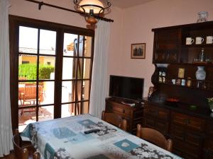 Zimmer mit einem Tisch, einem TV und einer Glasschiebetür in der Unterkunft Casa L'Estartit, 2 dormitorios, 4 personas - ES-323-56 in L'Estartit