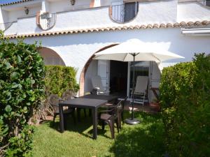 a table and chairs under an umbrella in the yard at Casa con Piscina y Cerca de la Playa en L'Estartit - ES-323-65 in L'Estartit