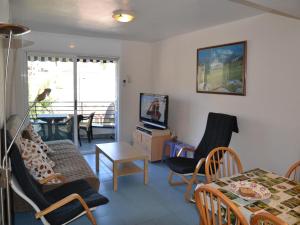 ein Wohnzimmer mit einem Tisch, Stühlen und einem TV in der Unterkunft Apartamento L'Estartit, 2 dormitorios, 4 personas - ES-323-36 in L'Estartit