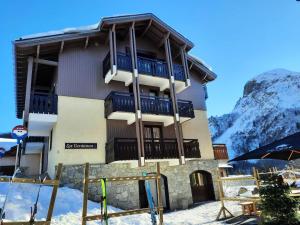 a building in the mountains with snow on the ground at Résidence Gentianessmb - 2 Pièces pour 4 Personnes 964 in Saint-Martin-de-Belleville