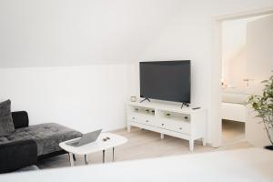uma sala de estar com televisão numa cómoda branca em Ferienwohnung in Memmingen em Memmingen