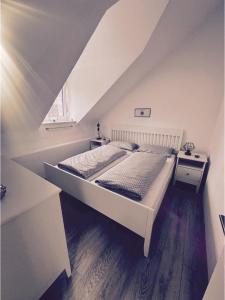 uma cama branca num quarto com uma janela em Ferienwohnung in Memmingen em Memmingen