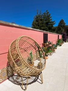 烏斯奇基的住宿－BOHO HOUSE，一张柳条椅,坐在粉红色的墙上