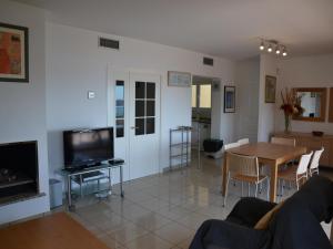 a living room with a couch and a table and a television at Casa Mediterranea - L'Estartit, Roca Maura - ES-323-70 in L'Estartit