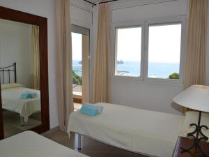 a bedroom with two beds and a large window at Casa Mediterranea - L'Estartit, Roca Maura - ES-323-70 in L'Estartit +27 photos