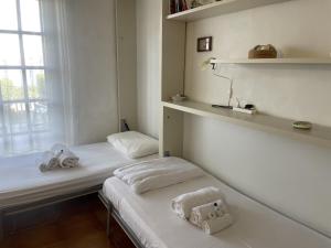 two beds in a small room with a window at Punta Est Giardino e Vista Mare in Capo Coda Cavallo