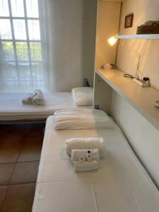 two beds in a room with towels on them at Punta Est Giardino e Vista Mare in Capo Coda Cavallo