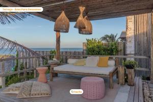 a porch with a couch and a view of the ocean at Casa Desert Point com piscina vista mar por Tactu in Taíba