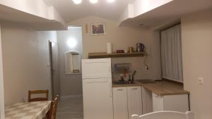 a small kitchen with a white refrigerator and a table at Apartamenty Warka in Warka