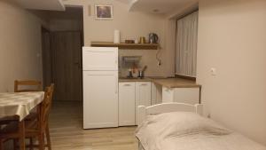 a kitchen with a white refrigerator and a table at Apartamenty Warka in Warka