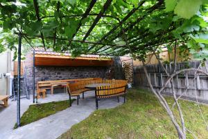 a patio with benches and a table and a tree at Hotel Almi in Akhaltsikhe