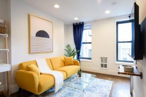 a living room with a yellow couch and a glass table at 69-5A Modern Lower East Side 1BR Apt BRAND NEW in New York