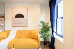 紐約的住宿－69-5A Modern Lower East Side 1BR Apt BRAND NEW，客厅里设有一张黄色的沙发,客厅里设有窗户