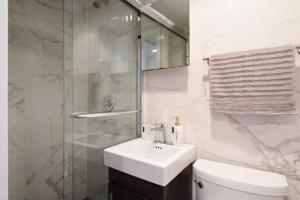 紐約的住宿－69-5A Modern Lower East Side 1BR Apt BRAND NEW，浴室配有卫生间、盥洗盆和淋浴。