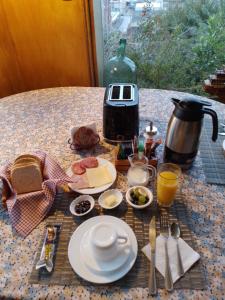 a table with a breakfast of food and a coffee maker at Portal Austral in Puerto Montt