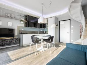 cocina y sala de estar con mesa y sillas en Delfi - amazing design apartment with Lake view, en Parzanica