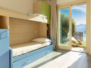 Habitación pequeña con litera y balcón. en Delfi - amazing design apartment with Lake view, en Parzanica