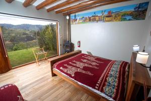 1 dormitorio con cama y ventana grande en Llullu Llama Mountain Lodge, en Hacienda Provincia