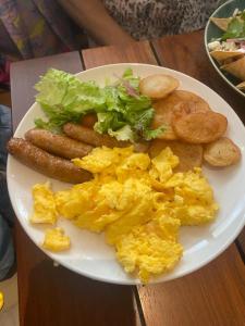- un plateau de petit-déjeuner composé d'œufs, de saucisses et de pommes de terre dans l'établissement PDC HOTELS, à Playa del Carmen