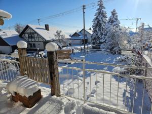 ein mit Schnee bedeckter Zaun neben einem Haus in der Unterkunft Alte Ölmühle, später Schäfershaus in Donaueschingen