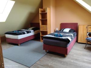 ein Schlafzimmer mit 2 Betten und einem Regal in der Unterkunft Alte Ölmühle, später Schäfershaus in Donaueschingen