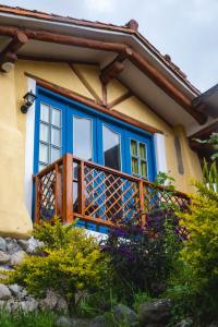ein blaues und gelbes Haus mit einem Balkon in der Unterkunft Llullu Llama Mountain Lodge in Hacienda Provincia