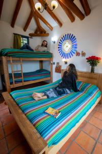Dos personas tumbadas en una cama en un dormitorio en Llullu Llama Mountain Lodge, en Hacienda Provincia