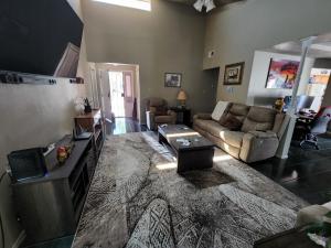 a living room with a couch and a tv at Buckboard House in Rio Rancho