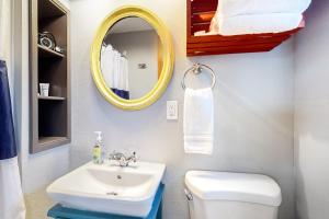een badkamer met een wastafel, een spiegel en een toilet bij Breakwater Inn - Mastodon Cottage #G in Grayland