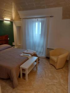 a bedroom with a bed and a chair and a window at hotel scaffe in Pennapiedimonte