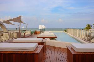 a swimming pool with chaise lounges and the ocean at Setai Yacht Premium - By Almare Flats in João Pessoa