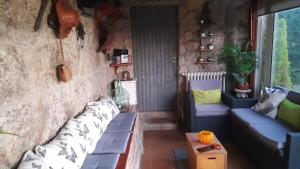 A Leiriña - Casa rural para desconexión في La Cañiza: غرفة معيشة مع أريكة وطاولة