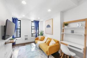 a living room with a couch and a tv at 69-5B I Stylish Lower East Side 1BR Apt BRAND NEW in New York