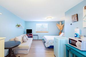 a living room with a couch and a bed in a room at Breakwater Inn - Towhee Cottage #F in Grayland